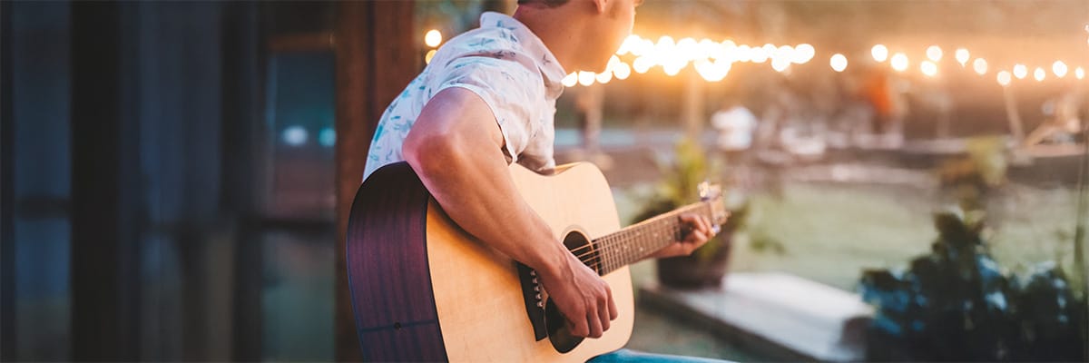 Musician playing guitar at a Gulf Coast beach resort, creating a relaxed atmosphere for guests